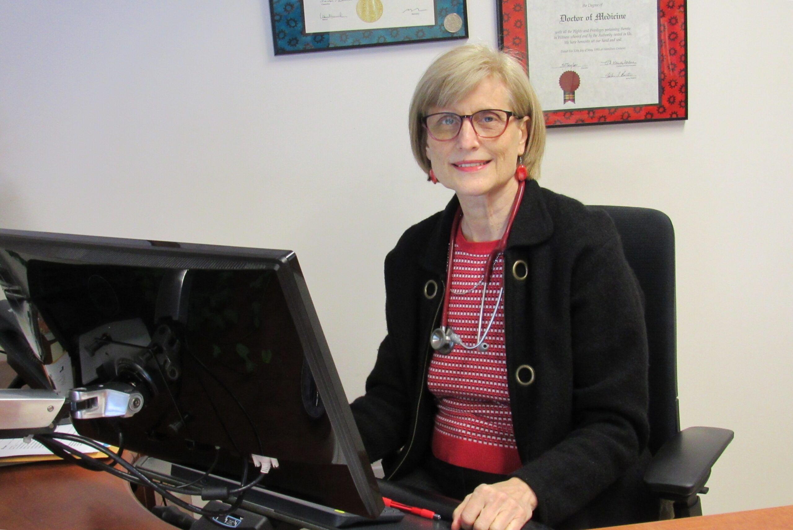 Dr. Elena Mihu at her desk smiling